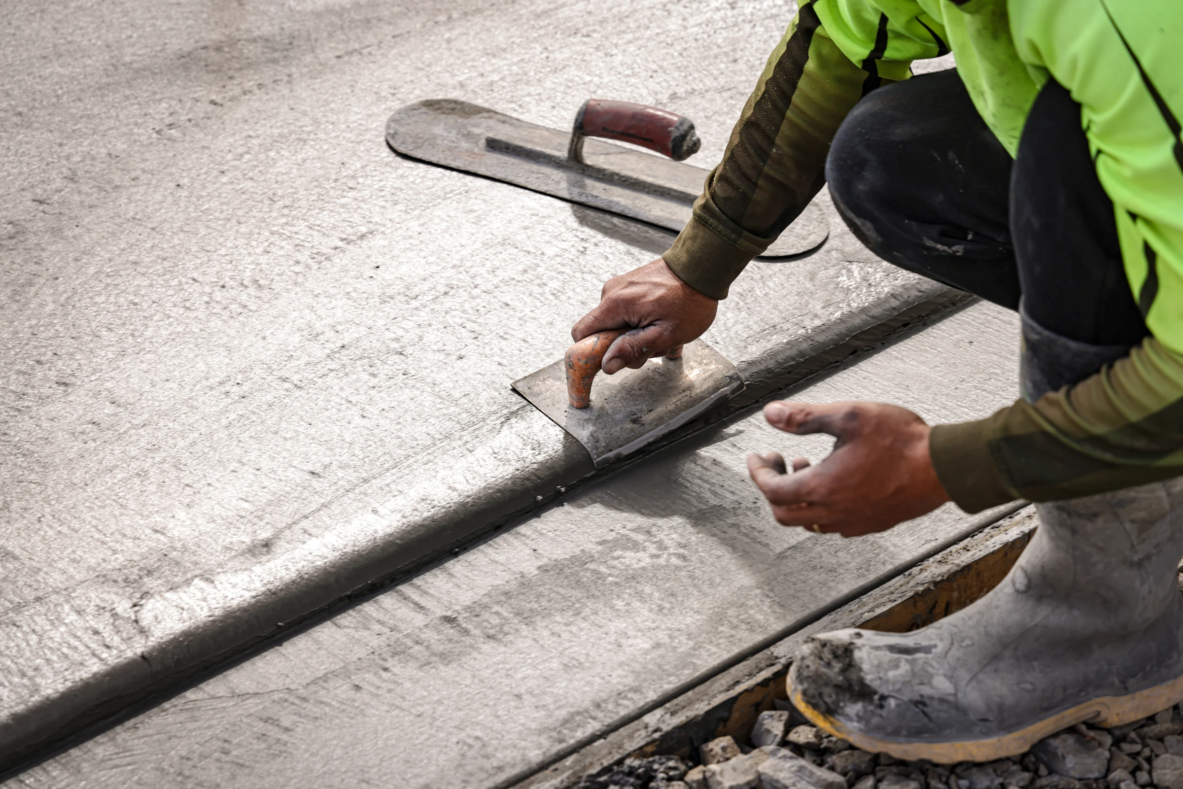 Livic Civil concreter finishing the edge of a fresh concrete pavement.