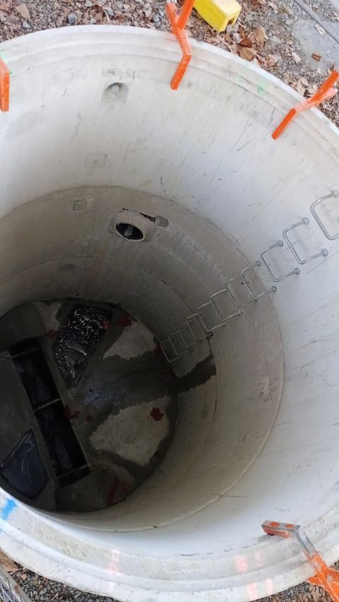 Precast concrete manhole chamber with an installed access ladder.