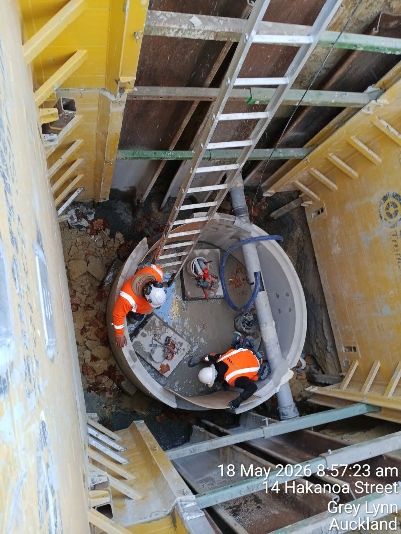 Crew installing pipework in a supported excavation.