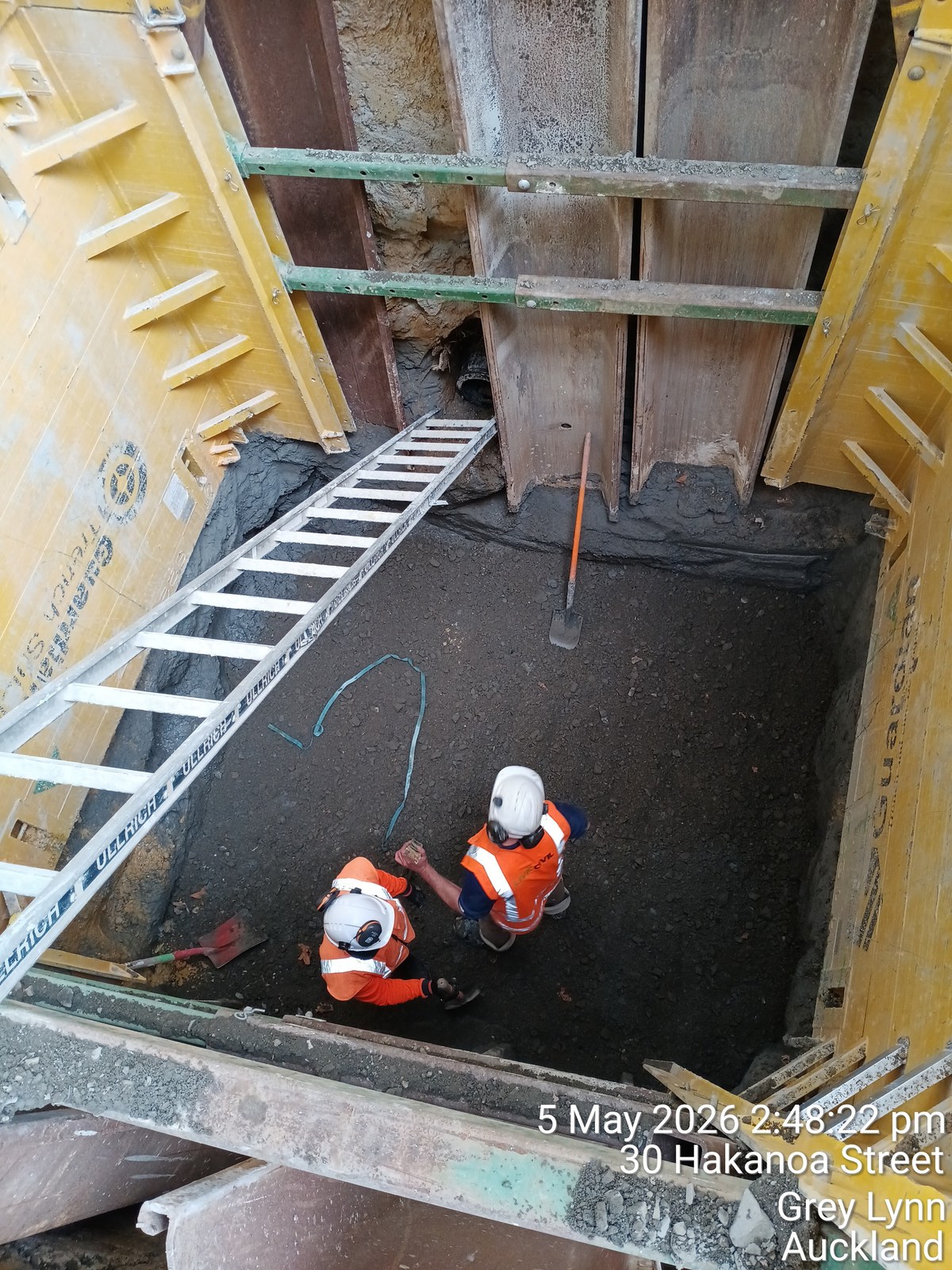 Two workers checking the base of a supported Hakanoa Street stormwater trench.