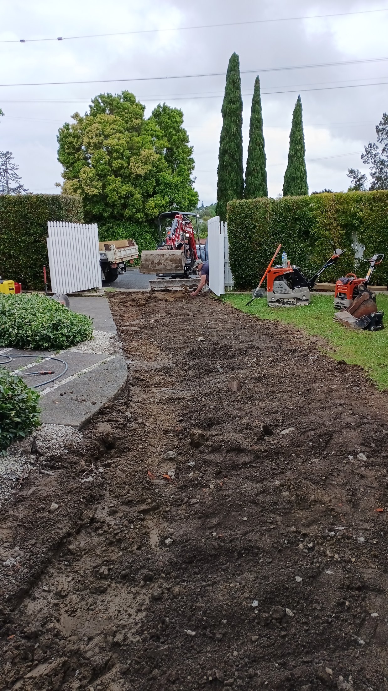 Driveway base preparation and compaction equipment at the residential site.