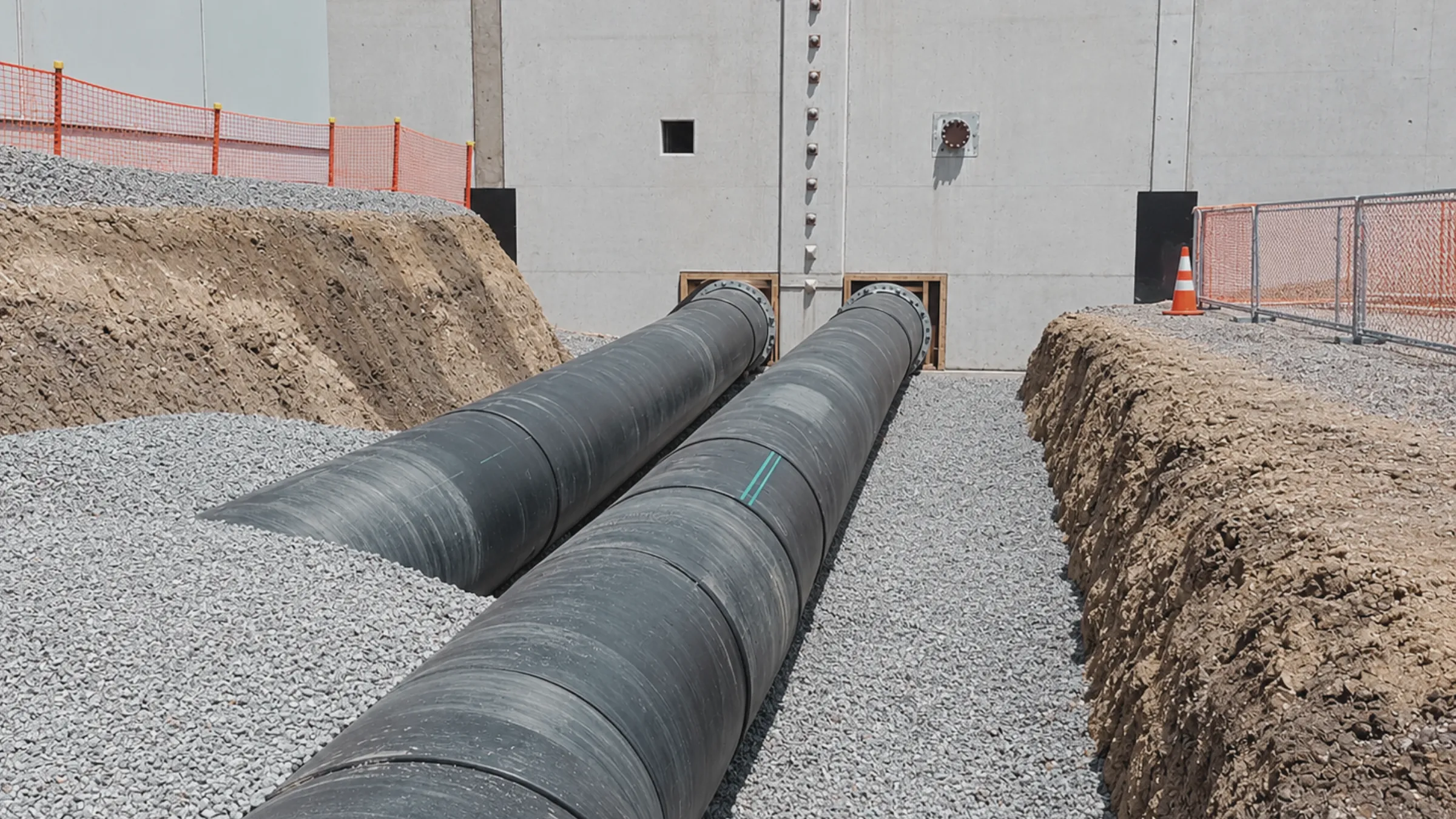 Two large pipelines installed at a wastewater treatment facility.
