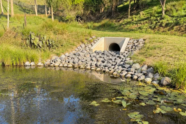 Rock-lined stormwater outfall discharging to a remediated stream.